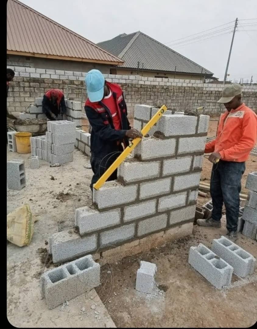 Mason checking blockwork alignment with a spirit level