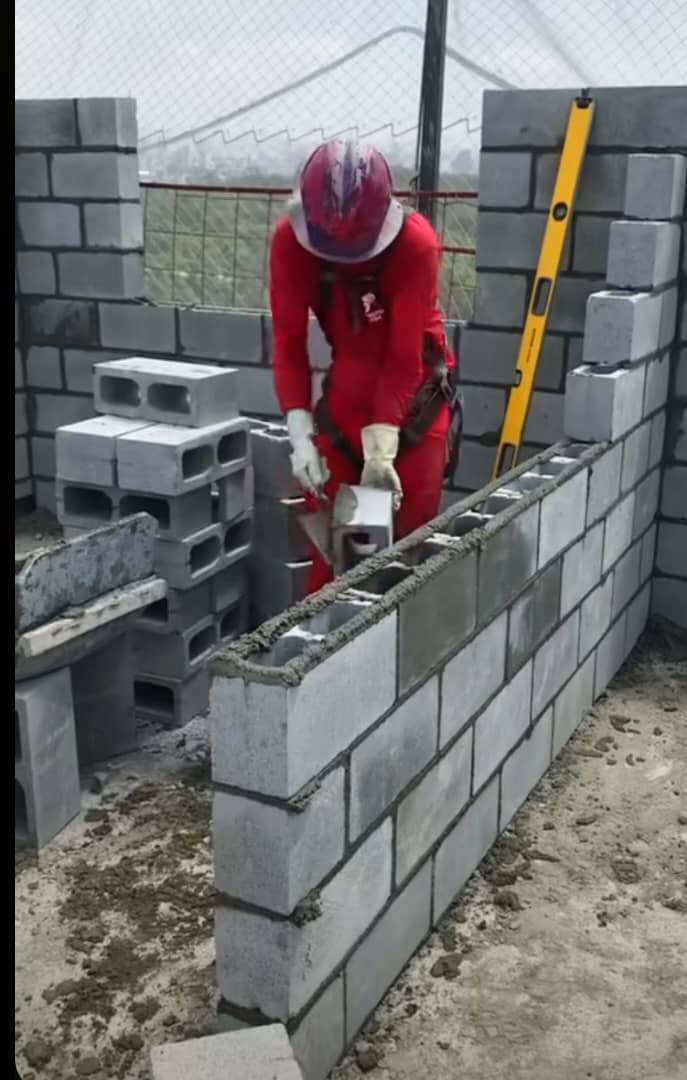 Crew member laying blocks to a precise, level line