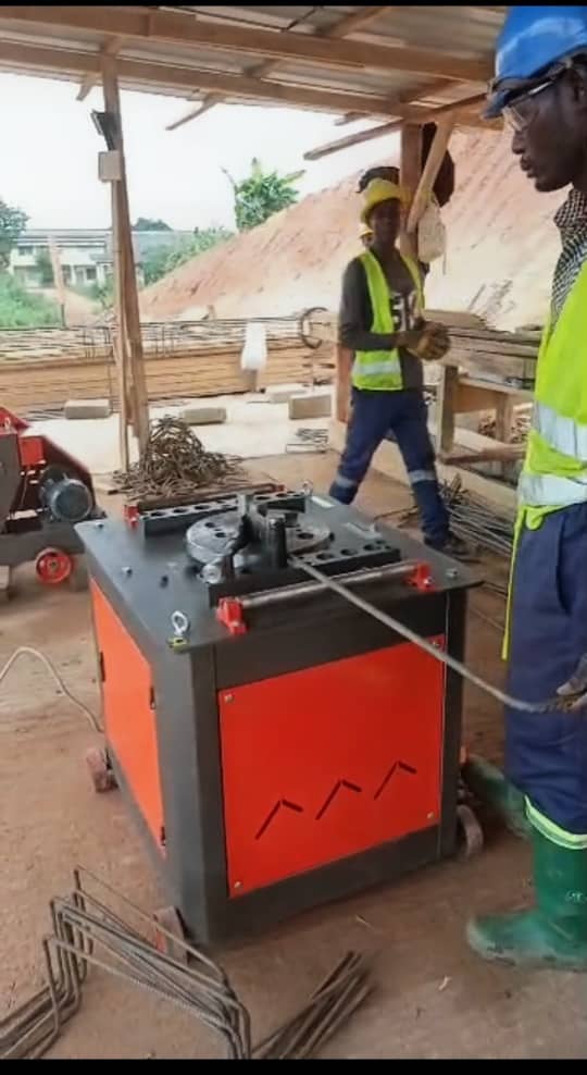 Crew operating a rebar bending machine on site