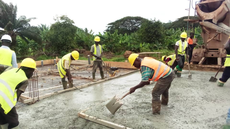 Crew in PPE finishing a concrete slab pour