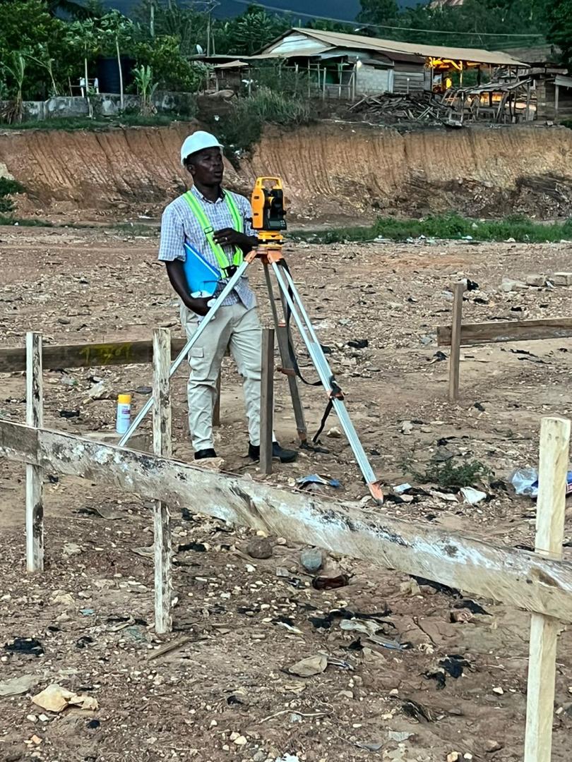 Surveyor using a total station on site